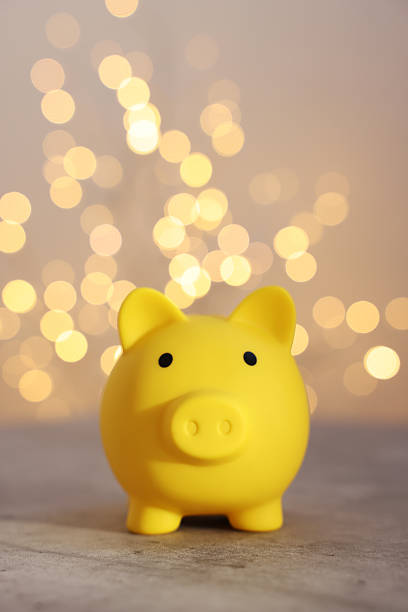 istock Yellow piggy bank on grey table against blurred lights 2246053152