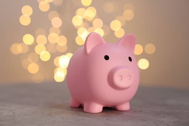 istock Pink piggy bank on grey table against blurred lights 2246053187