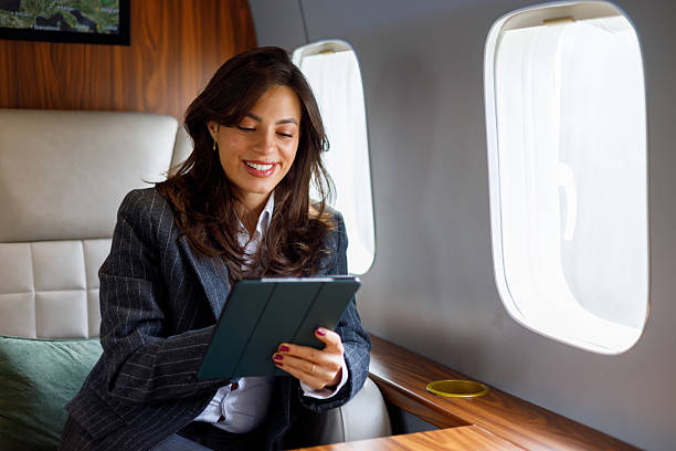 istock Businesswoman riding on private jet, smiling while using digital tablet, connecting during luxury corporate travel 2246053325