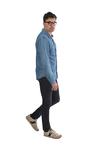 istock serious man walking and looking at camera on white background 2246055179