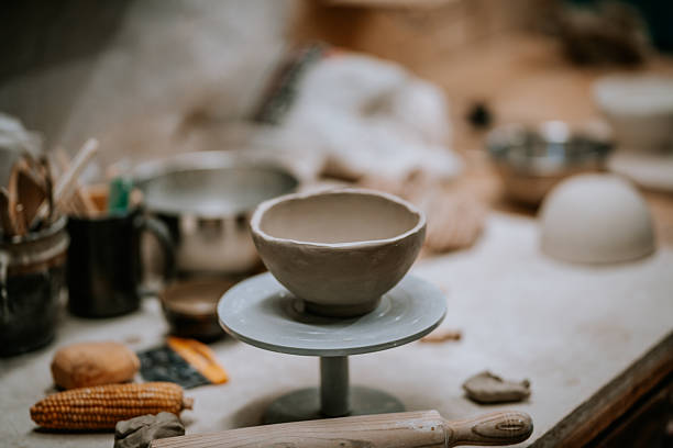 istock Ceramic bowl on a pottery wheel, surrounded by tools and materials, showcasing the artistry of pottery making in a creative workshop environment with natural lighting 2246056473