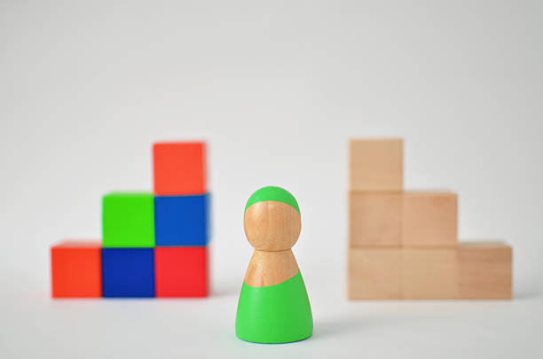 istock Wooden figure making a choice between colorful and plain blocks 2246058801