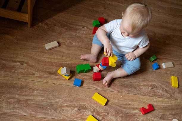 istock Child Engaging with Multicolored Wooden Toys for Development 2246060299