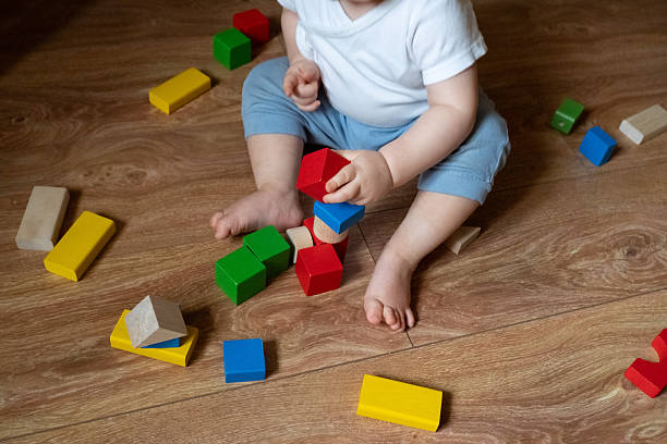 istock Child Engaging with Multicolored Wooden Toys for Development 2246060331