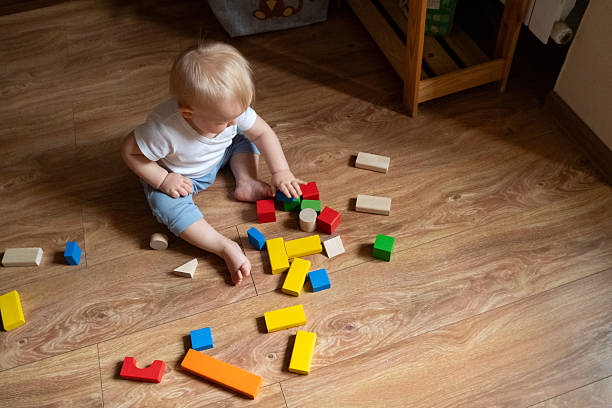 istock Child Stacking Colorful Blocks on Wooden Floor 2246060904