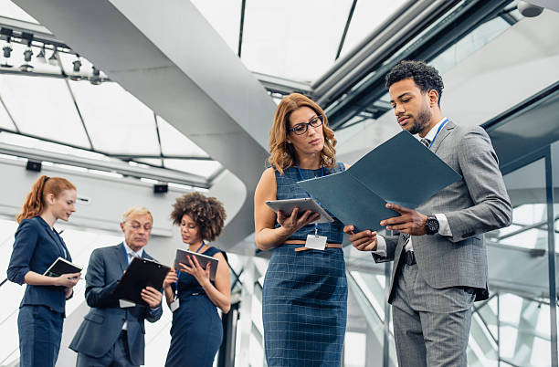 istock Diverse Group of Business Professionals Exchanging Ideas in Office Hallway 2246061796