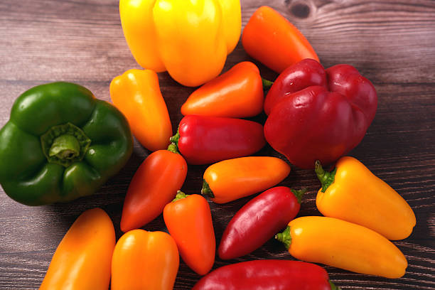 istock vibrant array of multi-colored bell peppers and mini peppers on wooden surface highlighting freshness and organic texture, decor, appetizing, market, gourmet, foodie, pattern, rustic, smooth, shape 2246062701