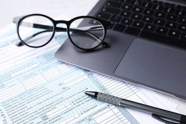 istock Tax forms, pen, glasses and laptop on table, closeup 2246063470