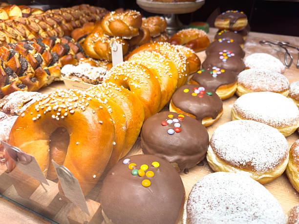 istock Assorted fresh pastries and donuts with chocolate and sugar coating displayed on wooden counter 2246063550