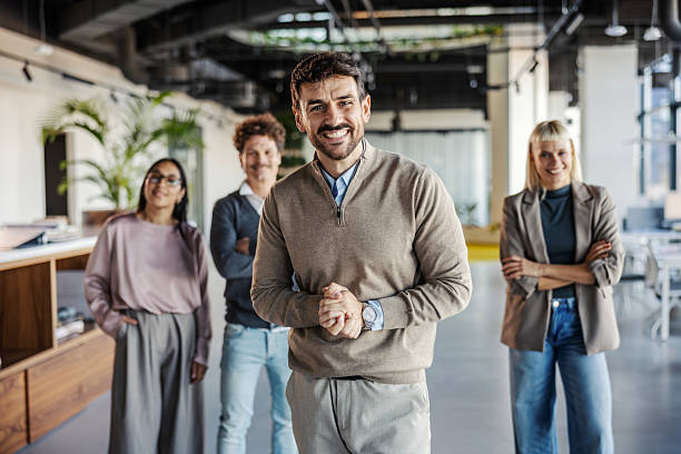 istock Happy business team standing together in modern office 2246065531