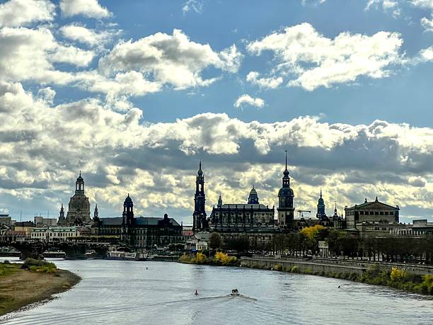 Dresden cityscape with historic architecture lining the elbe river under a cloudy sky