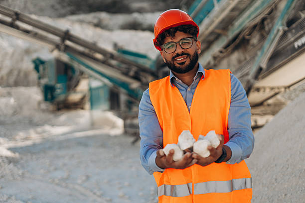 Successful Middle Eastern Engineer holding white limestone rocks in hands at quarry site. Industry concept