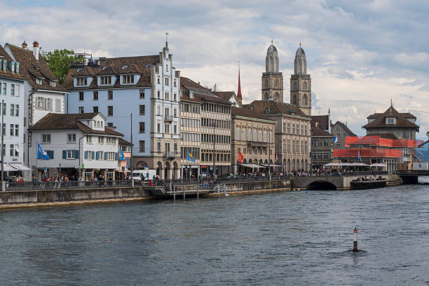 Panoramic view of Zurich old town with traditional Swiss buildings, bridges, and church towers along the Limmat river. Scenic urban landscape representing European culture and architecture.