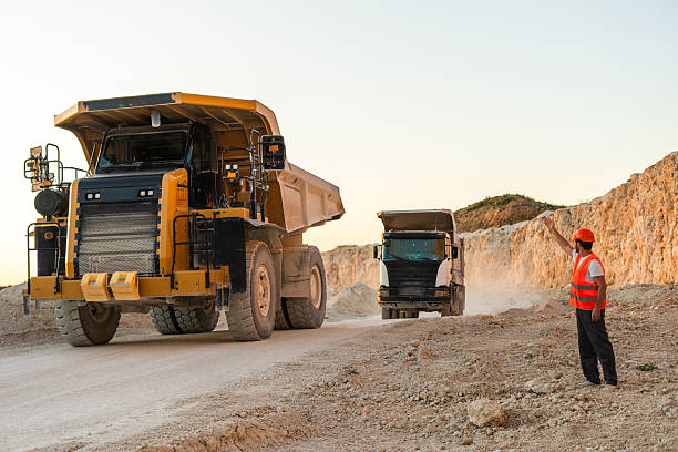 istock Large mining dump truck standing on a dusty quarry road surrounded by rocky terrain 2246066267