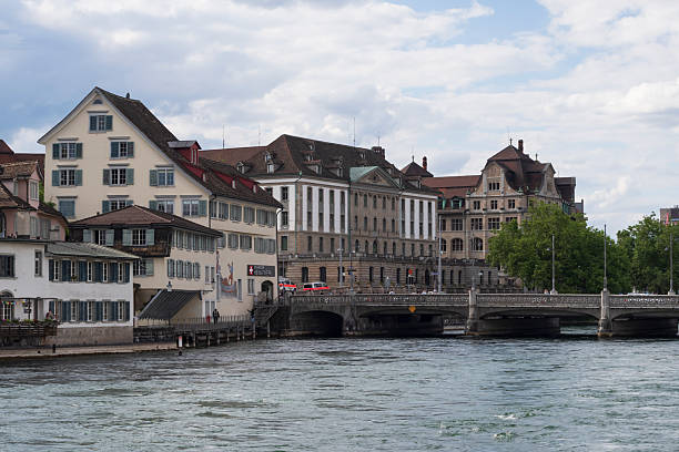 Panoramic view of Zurich old town with traditional Swiss buildings, bridges, and church towers along the Limmat river. Scenic urban landscape representing European culture and architecture.