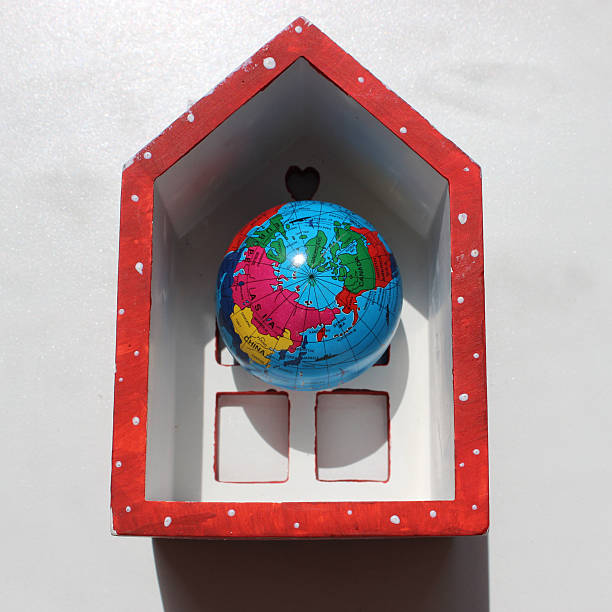 istock Toy Globe Inside Toy Hollow House On White Surface 2246071255