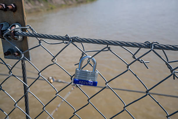 A heart-shaped lock on the chain above the lake on the bridge symbolizes a new family.