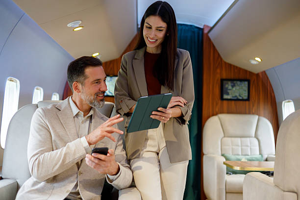 istock Business colleagues collaborating on private jet, discussing financial data or travel plans with digital tablet and smartphone 2246072906