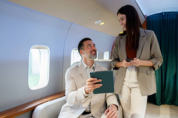 istock Business people discussing project flying in private jet, using digital tablet and smartphone 2246073407