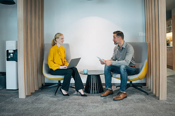 istock Business professionals discussing work in office lounge area 2246074952