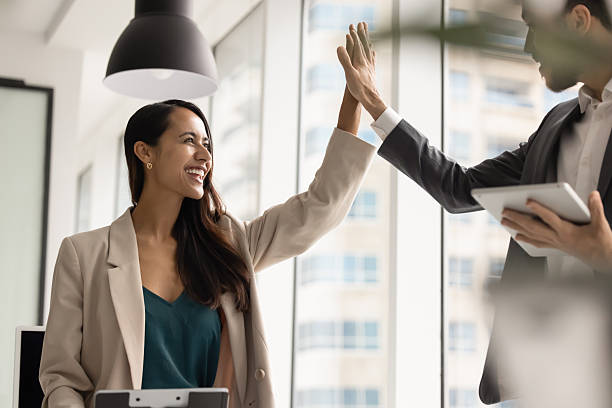istock Two office friends enjoying teamwork, giving high five 2246077418