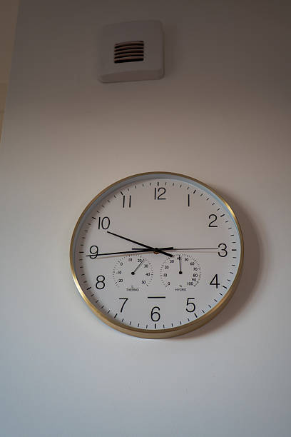 istock Round wall clock with gold rim and dials in modern Gdansk flat 2246081800