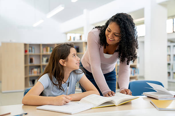 istock Happy teacher talking to a young student at the library 2246082290