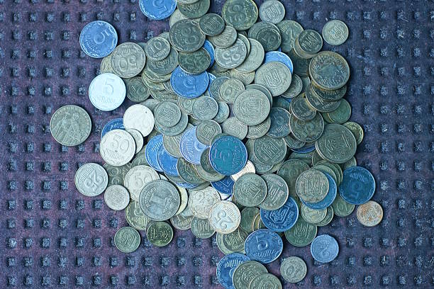 heap of yellow and white small coins on a brown table
