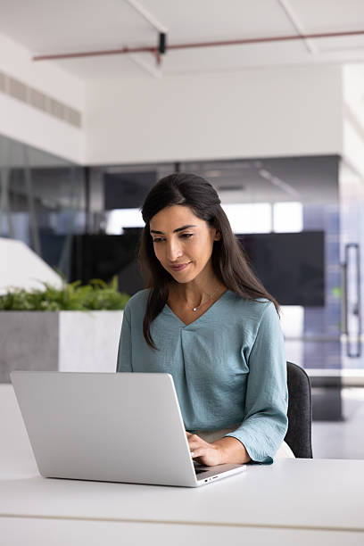 istock Positive Hispanic freelancer woman typing on laptop in co-working space 2246084653
