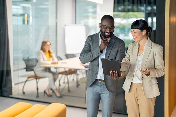 istock Smiling business people collaborating using digital tablet in modern office 2246084924