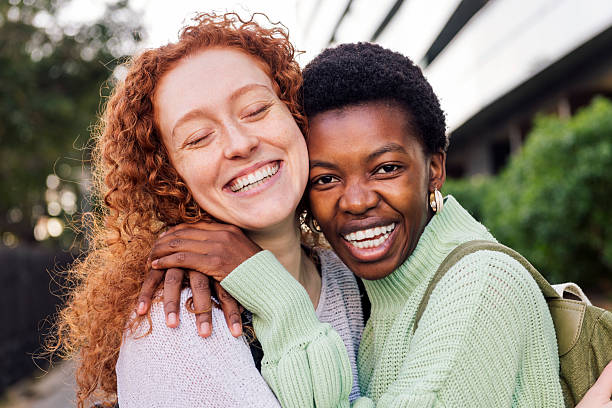 istock two young women hugging and laughing happy 2246085127