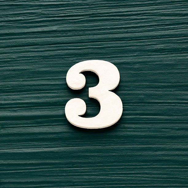 istock Number three - White wooden number on a rustic dark green background 2246086146