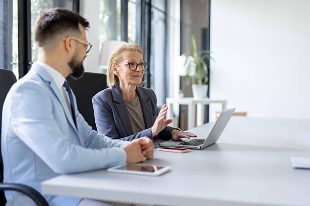 istock Business Team Collaborating Over Laptop in Office Setting 2246086702