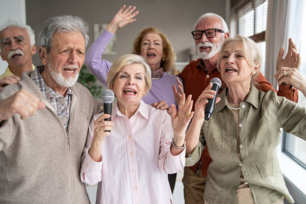 istock Happy seniors singing together with microphones in harmony 2246086985