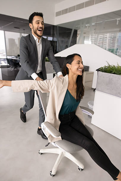 istock Joyful young office workers riding on chair 2246088937