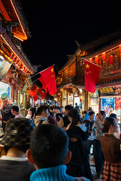 Lijiang, China - October 13th, 2025: View of Lijiang old town by night with crowds of people and tourists on the street.