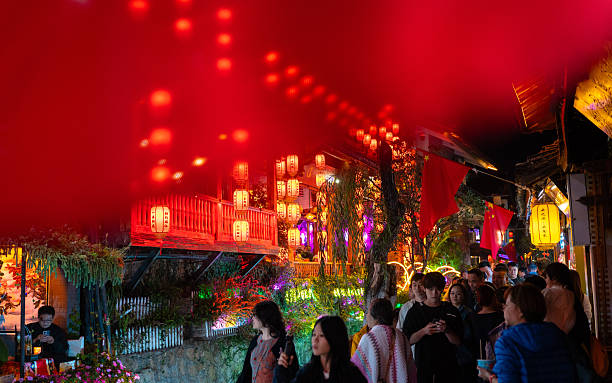 Lijiang, China - October 13th, 2025: View of Lijiang old town by night with crowds of people and tourists. A vibrant night life.