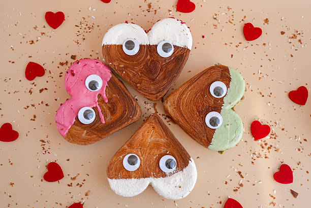 istock Funny creative faces with eyes Flat lay greeting card Valentine's Day Delicious fresh variety croissants topped with colorful flavor Ganache. Creation unique heart shape bakery. Puff pastry holiday love gift present idea 2246103871