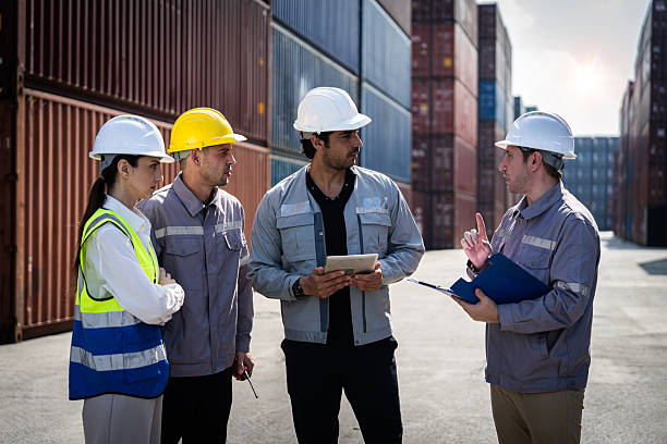 istock A group of construction workers are standing in a warehouse, discussing a project. They are wearing hard hats and safety vests 2246105311