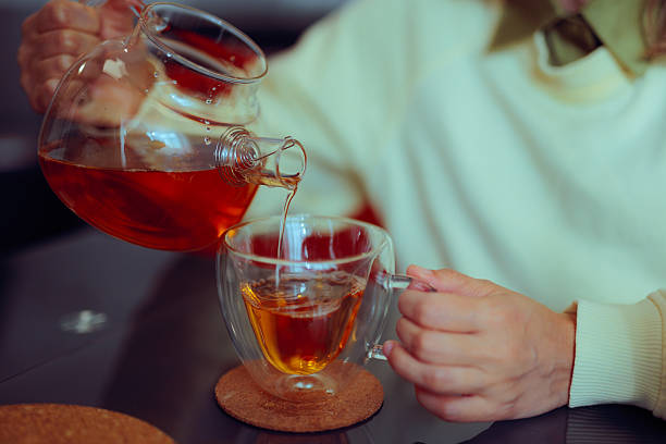 istock Person Holding a Teapot Pouring Tea into a Cup 2246111504