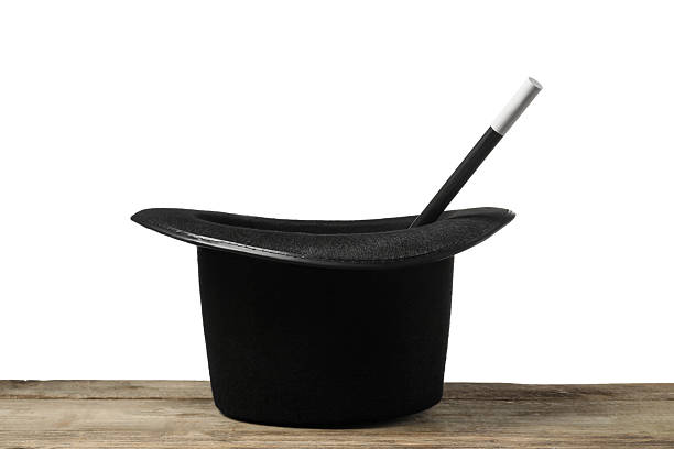 istock Magician's hat and wand on wooden table against white background 2246120379