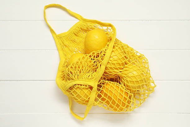 istock String bag with fresh lemons on white wooden background, top view 2246121317