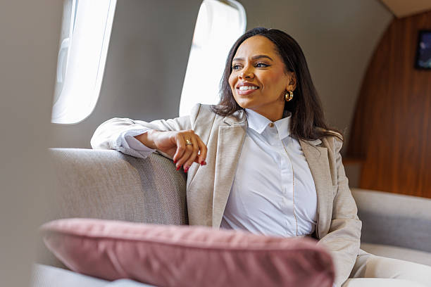 istock Businesswoman looking through private jet window feeling successful 2246121602
