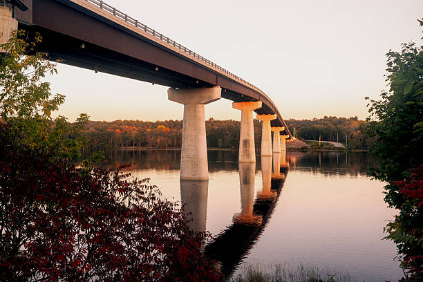 istock Bridge over calm lake at sunset in autumn forest 2246126415