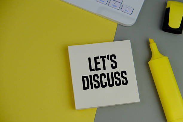 istock Top view image of white sticky note with text LET'S DISCUSS on grey and yellow background with copy space. 2246127344