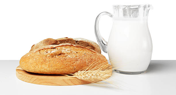 istock Freshly baked bread and milk served on a wooden board in a cozy kitchen setting 2246130421