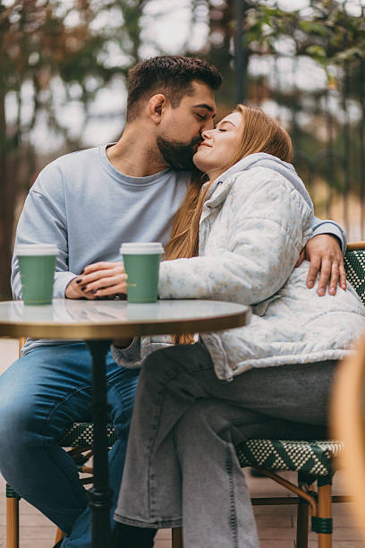 istock Romantic duo enjoys tender peck amidst autumn setting at cafe 2246131821