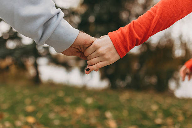 istock Hands embracing over colorful autumn leaves emphasizing closeness 2246132505