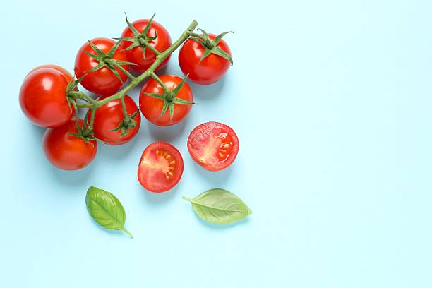 istock Tasty fresh cherry tomatoes, pepper on blue background. Ripe vegetables 2246134589