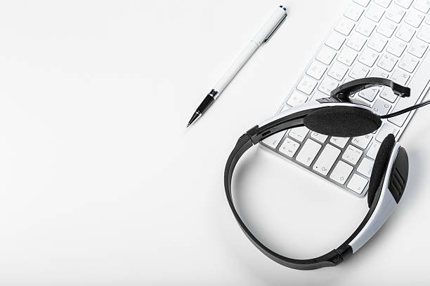 istock Headset and keyboard on a clean desk surface for remote work and communication tasks 2246138253